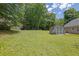 Spacious backyard featuring a storage shed, green lawn and surrounding trees at 2416 Hurt Sw Rd, Marietta, GA 30008