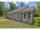 Rear exterior of the house with a sunroom, a patio, and green grass at 2416 Hurt Sw Rd, Marietta, GA 30008