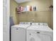 Laundry room with full-size washer and dryer, plus overhead storage shelving at 2416 Hurt Sw Rd, Marietta, GA 30008