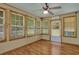 Cozy sunroom featuring many windows, ceiling fan and light-colored wood flooring at 2416 Hurt Sw Rd, Marietta, GA 30008