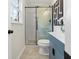 Stylish bathroom features walk-in shower with glass door, blue vanity, and neutral tile flooring at 6974 Clearlake Ct, Peachtree Corners, GA 30360