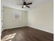 Neutral bedroom features ceiling fan, large window, fresh paint, and dark wood-look flooring at 6974 Clearlake Ct, Peachtree Corners, GA 30360