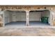 Two-car garage with stone trim, built-in shelves, and painted concrete floors at 6974 Clearlake Ct, Peachtree Corners, GA 30360