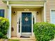 Charming front door with a 'Welcome' wreath and manicured shrubs, creating an inviting entryway at 220 Baltimore Ave, Stockbridge, GA 30281