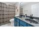 Bright bathroom featuring a double sink vanity, toilet, and shower with decorative shower curtain at 4104 Glenaire Nw Way, Acworth, GA 30101
