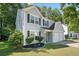 Side view of a charming two-story home with a two-car garage and manicured lawn, set among mature trees at 4104 Glenaire Nw Way, Acworth, GA 30101