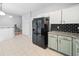 Modern kitchen with tiled floor, stainless steel appliances, and white and green cabinetry at 4104 Glenaire Nw Way, Acworth, GA 30101
