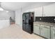Stylish kitchen with a black refrigerator, granite counters and tile flooring at 4104 Glenaire Nw Way, Acworth, GA 30101