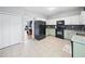 Well-lit kitchen boasts stainless steel appliances, light-green cabinetry, and tile flooring with access to the dining area at 4104 Glenaire Nw Way, Acworth, GA 30101