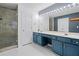 Well-lit main bathroom showing large mirror with vanity lights, dual sinks, glass shower, and closet at 4104 Glenaire Nw Way, Acworth, GA 30101