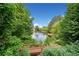 Scenic pond view framed by lush greenery and trees in a serene community setting at 4104 Glenaire Nw Way, Acworth, GA 30101