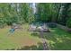 A lush backyard with mature trees, play area, and a fenced in above ground pool and deck at 7155 Bannister Park Ln, Cumming, GA 30028
