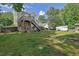 A large, grassy backyard with a wooden deck and stairs leading down from the house at 7155 Bannister Park Ln, Cumming, GA 30028
