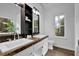 Bright bathroom featuring double sinks with granite countertops and a large window for natural light at 7155 Bannister Park Ln, Cumming, GA 30028