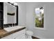 A bright bathroom with a single sink vanity, granite countertop, and a window with a view at 7155 Bannister Park Ln, Cumming, GA 30028