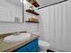 Modern bathroom with floating wood shelves, blue vanity, and a patterned shower curtain at 7155 Bannister Park Ln, Cumming, GA 30028