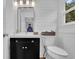 Cozy bathroom with shiplap walls, black vanity with star accents, and a decorative woven basket at 7155 Bannister Park Ln, Cumming, GA 30028