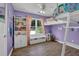 Purple bedroom featuring a unique bunk bed with built in storage, shelves, and a window seat at 7155 Bannister Park Ln, Cumming, GA 30028