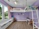 Bedroom featuring purple walls, wood flooring, lofted bed with ladder, and a window with natural light at 7155 Bannister Park Ln, Cumming, GA 30028
