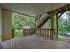 Covered deck with wooden flooring, overlooking a backyard, with access to both the house and yard at 7155 Bannister Park Ln, Cumming, GA 30028