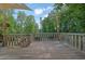 Spacious wooden deck with railings, surrounded by lush trees, perfect for outdoor relaxation at 7155 Bannister Park Ln, Cumming, GA 30028