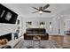 Bright and airy living room with a fireplace, ceiling fan, hardwood floors, and access to other rooms at 7155 Bannister Park Ln, Cumming, GA 30028