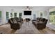 Bright living room with cozy seating, fireplace, ceiling fan, and hardwood floors at 7155 Bannister Park Ln, Cumming, GA 30028