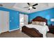 Blue main bedroom featuring tray ceilings, ceiling fan, and a sliding barn door to the bathroom at 7155 Bannister Park Ln, Cumming, GA 30028
