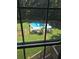 Backyard pool area featuring a large in-ground pool, surrounding deck with umbrellas, trampoline and lush landscaping at 7155 Bannister Park Ln, Cumming, GA 30028