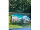 A spacious backyard pool area featuring an in-ground pool, a surrounding deck and umbrellas, and lush landscaping at 7155 Bannister Park Ln, Cumming, GA 30028