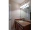 Bathroom vanity with granite countertop, mirror, and light fixture at 10110 Malcolm Ct, Covington, GA 30014