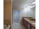 Bathroom with a long double sink vanity with stone countertop and tiled floor plus linen closet access at 10110 Malcolm Ct, Covington, GA 30014
