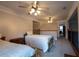 Spacious bedroom featuring two beds, plush carpet, and a ceiling fan at 10110 Malcolm Ct, Covington, GA 30014