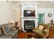 Cozy living room featuring a fireplace with decorative mantle, plush seating, and hardwood floors at 10110 Malcolm Ct, Covington, GA 30014