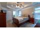 Comfortable main bedroom with tray ceiling, fan, ensuite access, and lots of natural light from the windows at 10110 Malcolm Ct, Covington, GA 30014