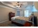 Comfortable main bedroom with tray ceiling, fan, ensuite access, and lots of natural light from the windows at 10110 Malcolm Ct, Covington, GA 30014
