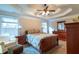 Comfortable main bedroom with tray ceiling, fan, ensuite access, and lots of natural light from the windows at 10110 Malcolm Ct, Covington, GA 30014