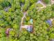 An aerial view displaying several residences with long driveways surrounded by lush green trees at 10213 Tall Pine Ct, Villa Rica, GA 30180