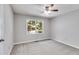 Bedroom with gray walls, ceiling fan, carpet flooring and large window with view to backyard at 10213 Tall Pine Ct, Villa Rica, GA 30180