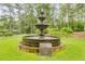 Tiered water fountain on a circular base situated on a green lawn with trees in the background at 10213 Tall Pine Ct, Villa Rica, GA 30180