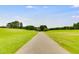 Scenic view of a smooth paved path winding through a well-kept green golf course on a sunny day at 10213 Tall Pine Ct, Villa Rica, GA 30180
