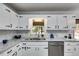 Stylish kitchen with granite countertops, stainless steel sink and appliances, and white cabinetry at 10213 Tall Pine Ct, Villa Rica, GA 30180