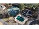 Aerial view featuring tennis courts, pool, and house with deck in wooded area at 3290 Coachmans Ne Way, Roswell, GA 30075