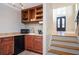 Home bar area with wood cabinets, a wine rack, a small sink, and access to the main entry stairs at 3290 Coachmans Ne Way, Roswell, GA 30075