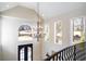Soaring foyer features a modern chandelier, arched window, and grand staircase at 3290 Coachmans Ne Way, Roswell, GA 30075