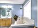 Modern bathroom featuring a soaking tub, vanity, and ample natural light, creating a serene and inviting atmosphere at 566 Lullingstone Se Dr, Marietta, GA 30067