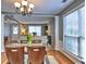 Open-concept dining area with glass table, chandelier, and a view extending into the living room at 566 Lullingstone Se Dr, Marietta, GA 30067