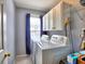 Laundry room features a washer, dryer, overhead cabinets, and a window at 566 Lullingstone Se Dr, Marietta, GA 30067