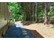 Exterior view of backyard with stone pavers, steps leading to the side of the house, and lush greenery at 580 Cliftwood Ct, Sandy Springs, GA 30328