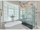 Bright bathroom features an oval tub next to a bay window and a glass shower with marble surround at 580 Cliftwood Ct, Sandy Springs, GA 30328